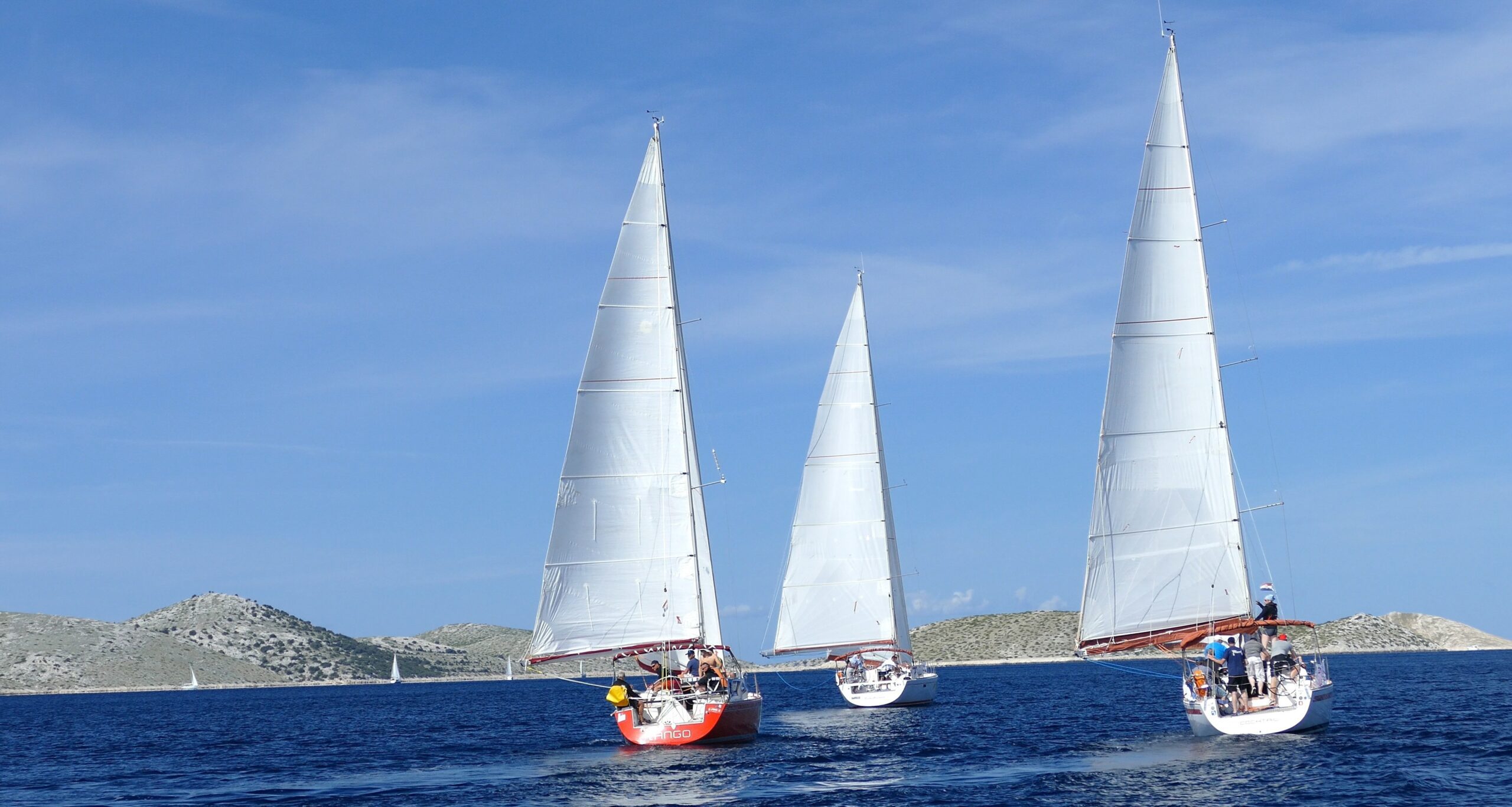 Three sailboats navigate the open ocean during a sailing team-building event in Zadar, Croatia.